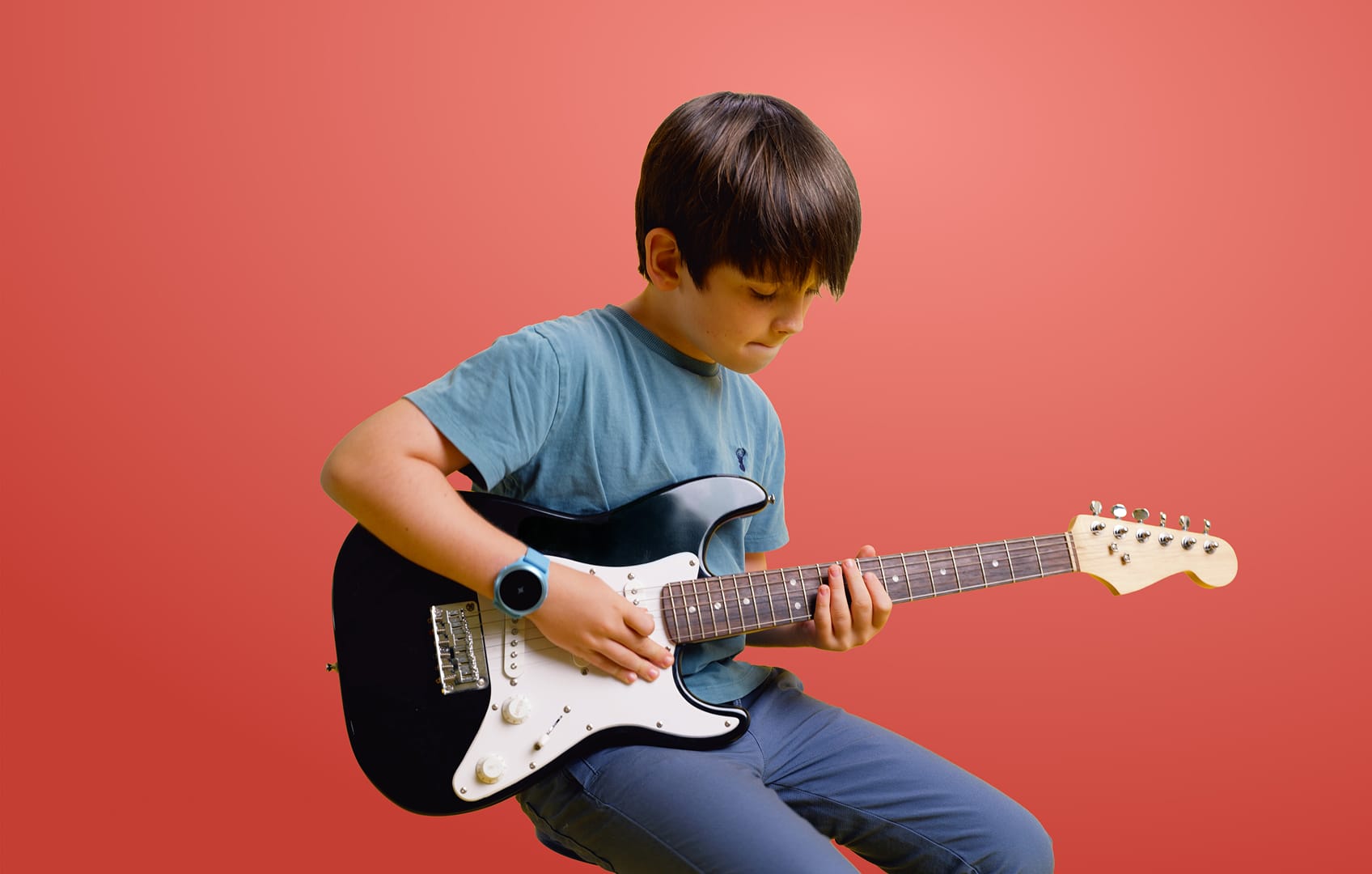 Menino tocando guitarra enquanto usa o Soundbrenner Spark
