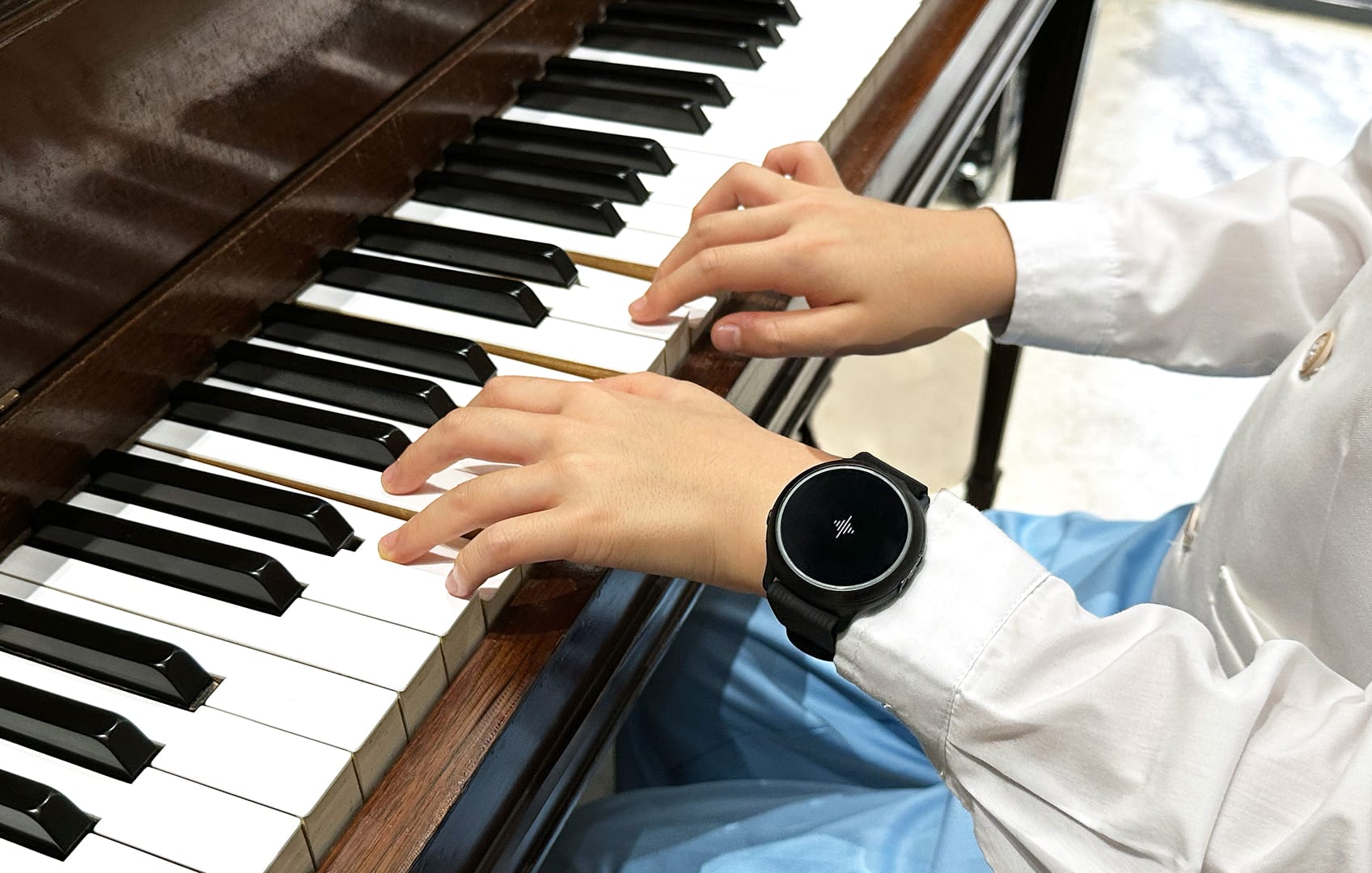 Menino usando Soundbrenner Spark enquanto toca piano