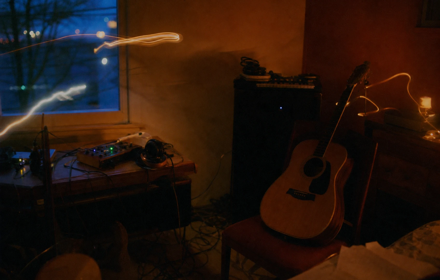 A lo-fi editorial collage of a small home recording room at dusk, with a guitar on a chair, a cheap mic stand, tangled cables, notebook pages, and tape-like paper textures in muted blues and rust reds.