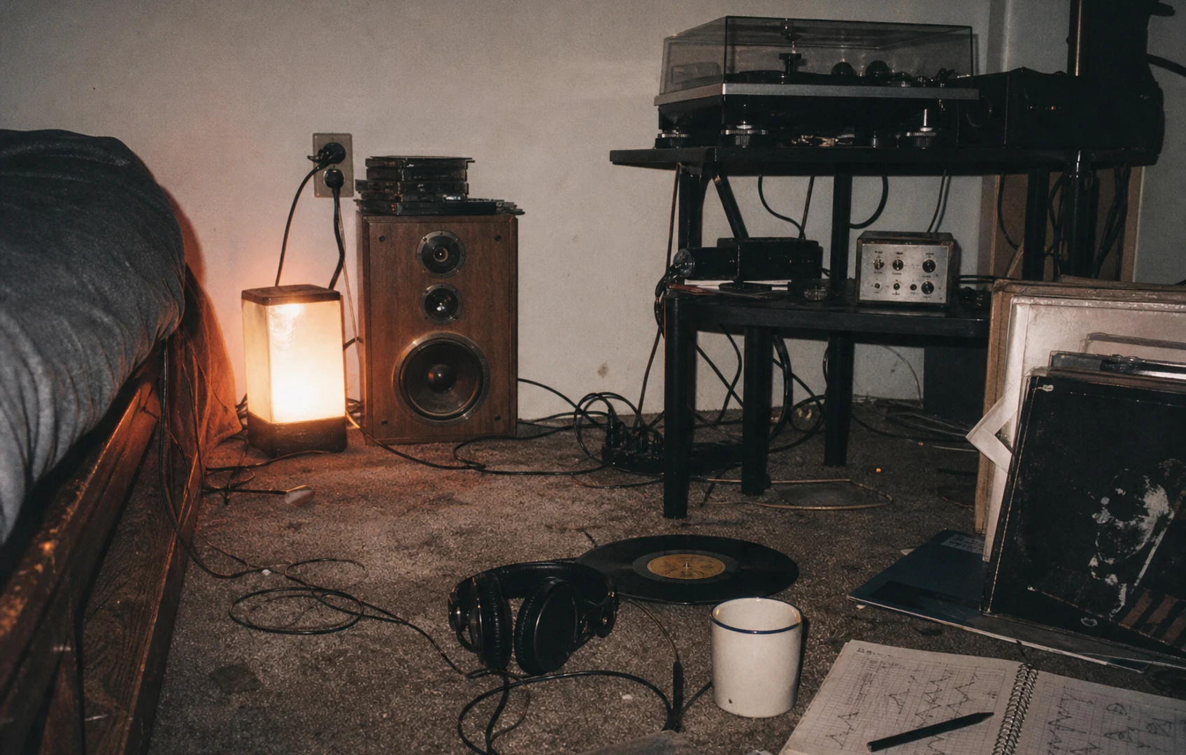 A lo-fi editorial collage of speaker shapes, waveforms, and cut-paper room outlines floating over a grainy midnight-blue background, suggesting sound adapting to different spaces.