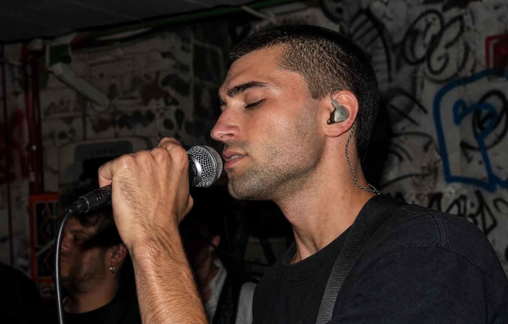 Singer performing with wired in-ear monitors on stage